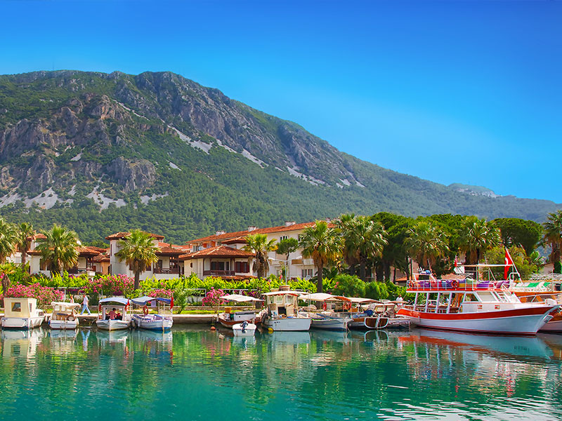 Bateaux accostés le long d'une ville longeant une montagne