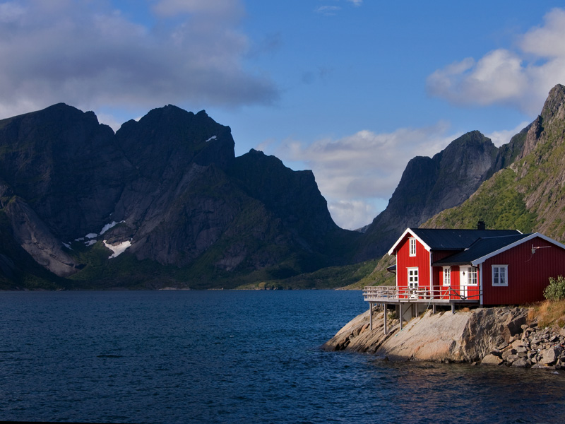 Cabane à pêche rouge devant les montagnes