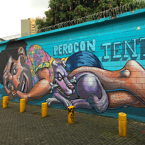 Dessin d'un homme couché avec son chien peint sur un mur en brique